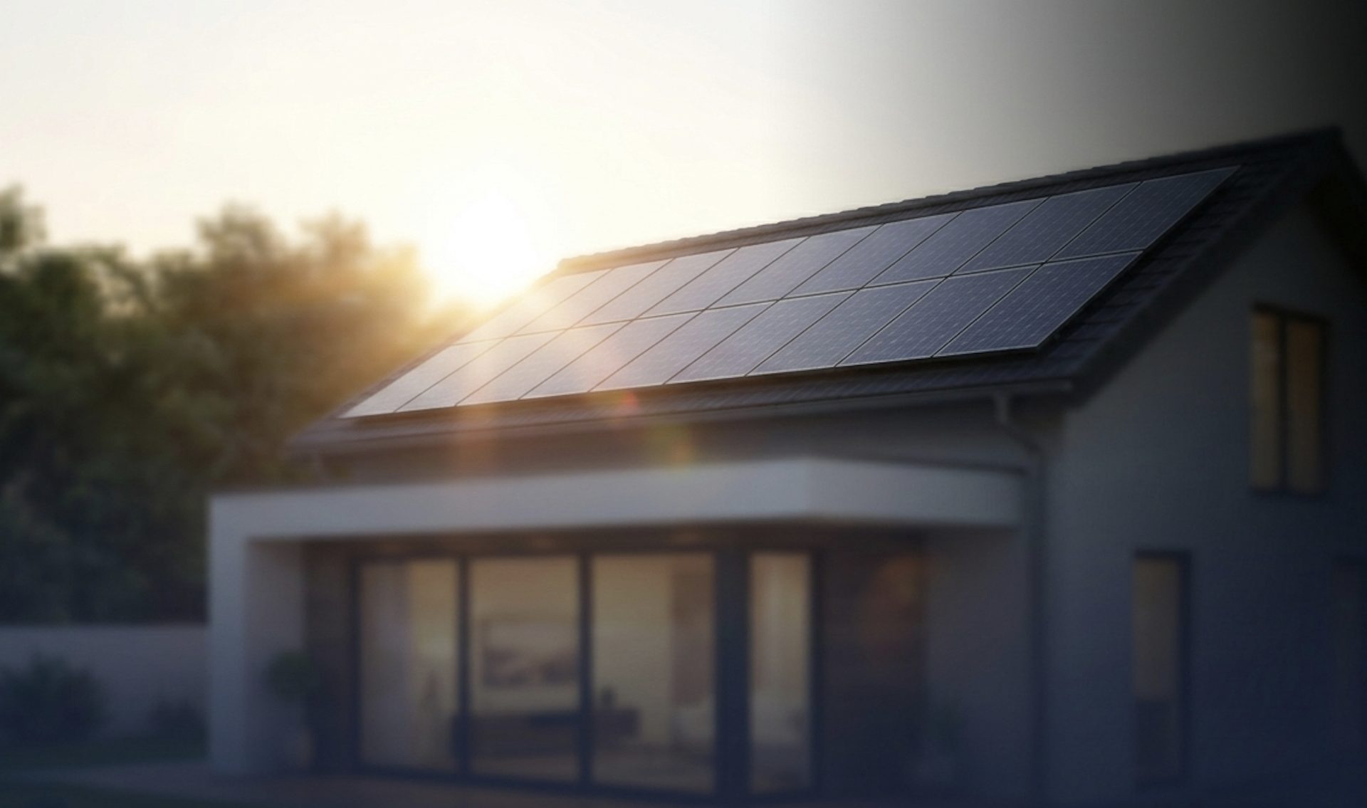 A home at golden hour with solar panels on the roof and warm light in the windows