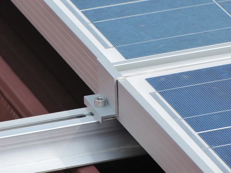 A mounting clamp holding a panel frame to its rail