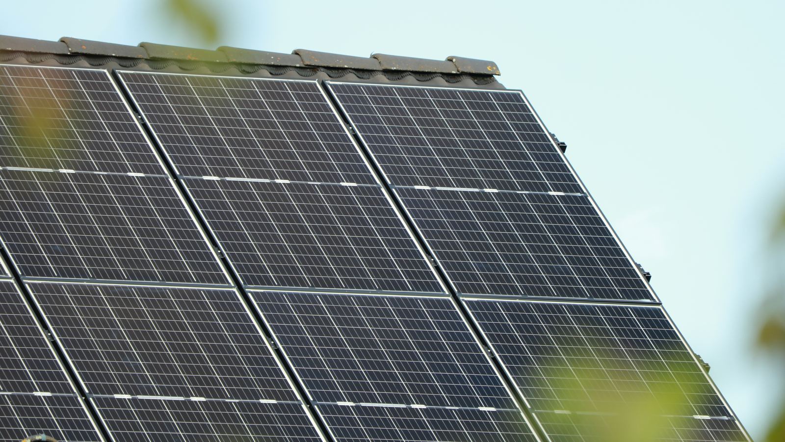 A finished array on a tiled roof against a bright sky